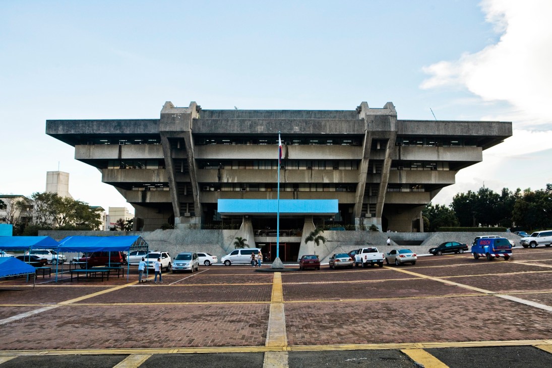 Brutalist concrete building with inverted pyramid design and horizontal striping, characteristic of 1970s architecture.