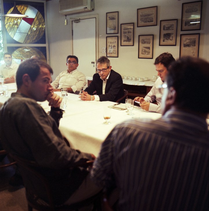 Otavio Frias Filho and editors seated at a white table during a lunch meeting at Folha de S.Paulo.