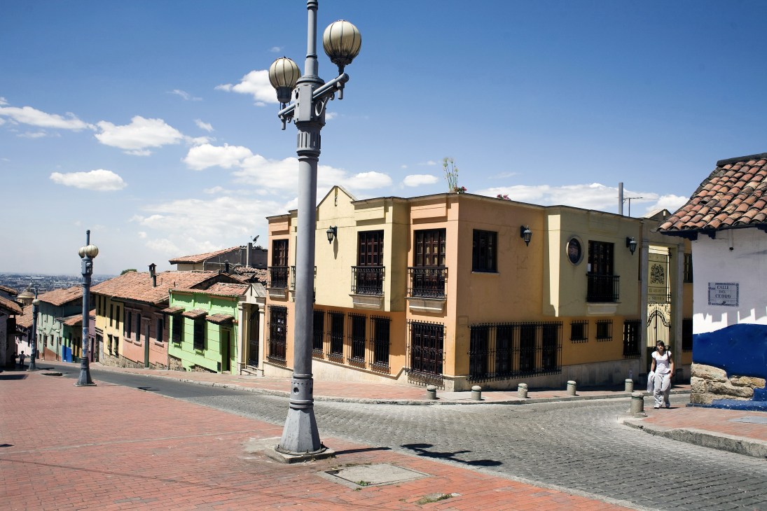 Colonial buildings with colourful facades line a cobblestone street in La Candelaria, Bogotá's historic neighbourhood.