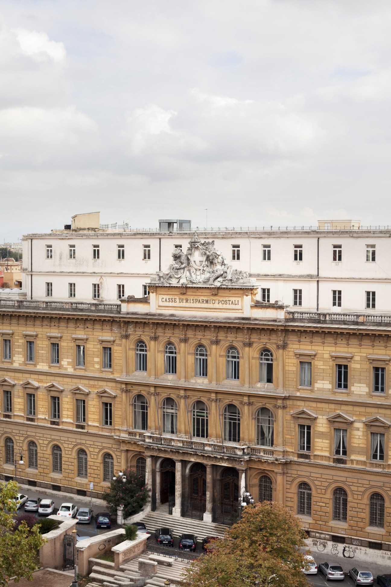 Grand neoclassical buildings with yellow stone facade and white upper structures in Rome's Esquilino neighbourhood.