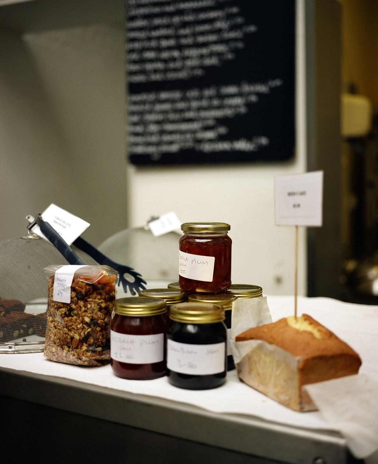 St John bakery's cake and preserve counter displaying jars of preserves, granola, and fresh bread.
