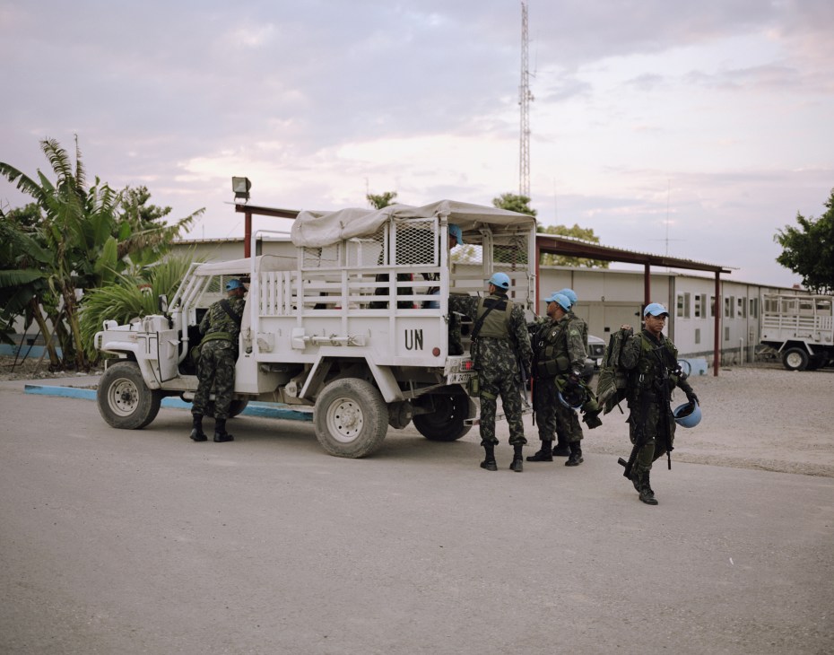 Brazilian UN peacekeeping troops board a white UN truck at General Barcellar Base in Haiti.