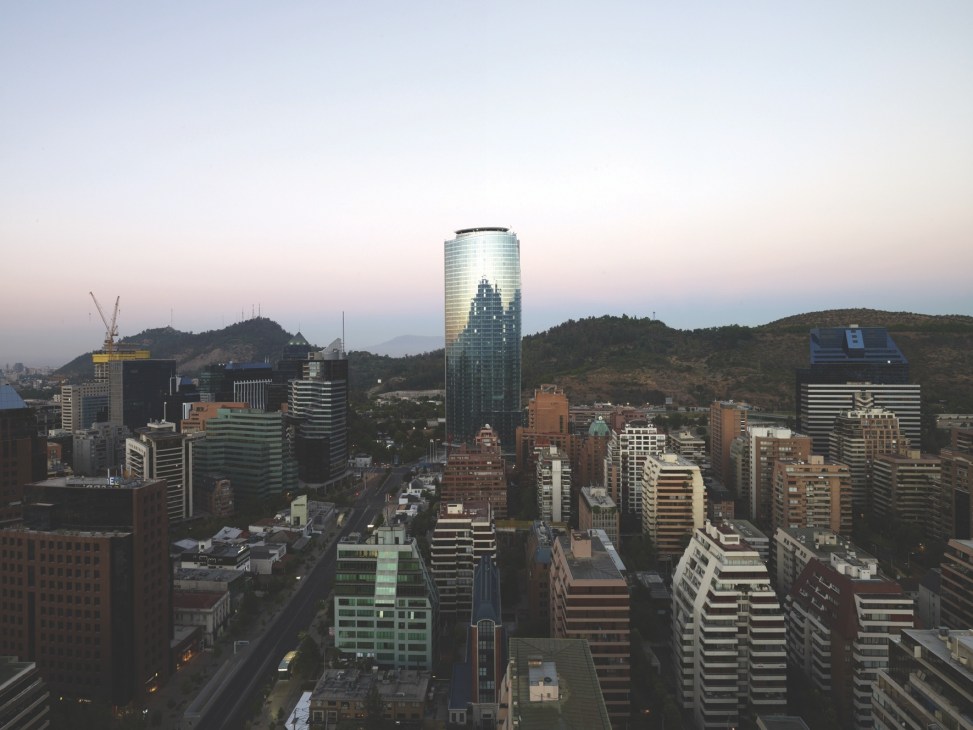 Titanium Tower rises prominently among Santiago's skyline with surrounding buildings and mountains in background.