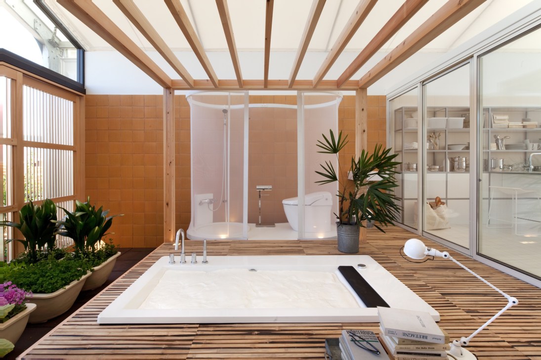 Modern bathroom with raised toilet and bedroom platform, wooden beams, and integrated plants by architect Toyo Ito.