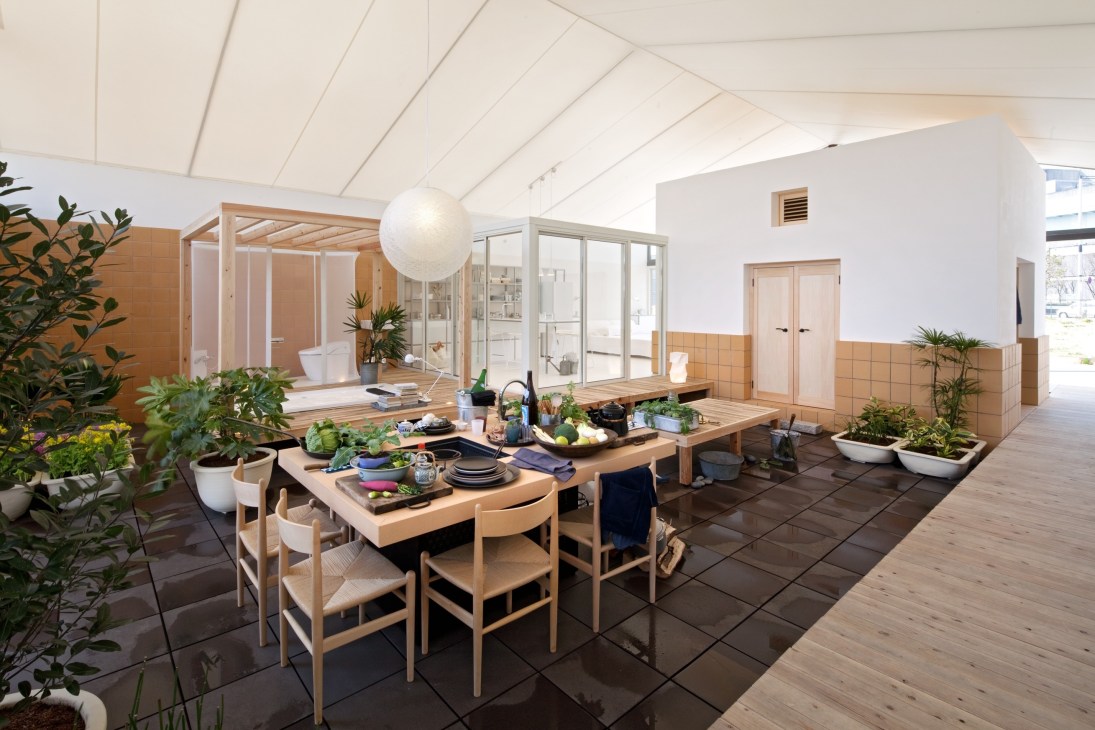 Modern dining area with wooden table, chairs, potted plants, and white ceiling in Toyo Ito's House Vision design.