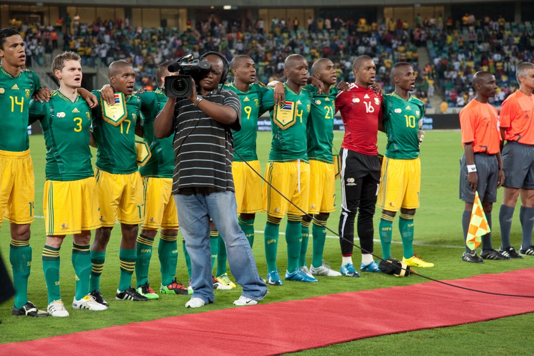 SABC cameraman films South African national team during anthem at Moses Mabhida stadium.