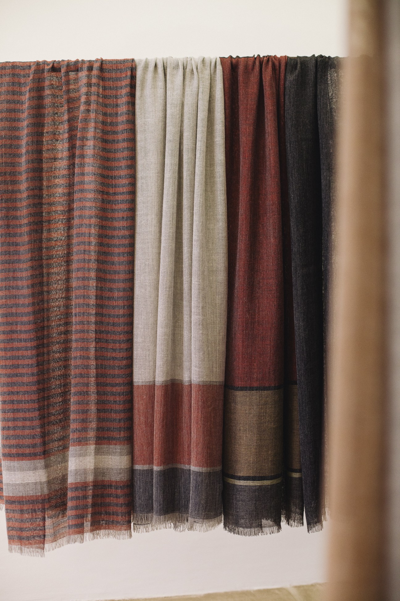 Wubet scarves in various colors displayed on a rod, showing traditional Ethiopian-inspired textile designs.