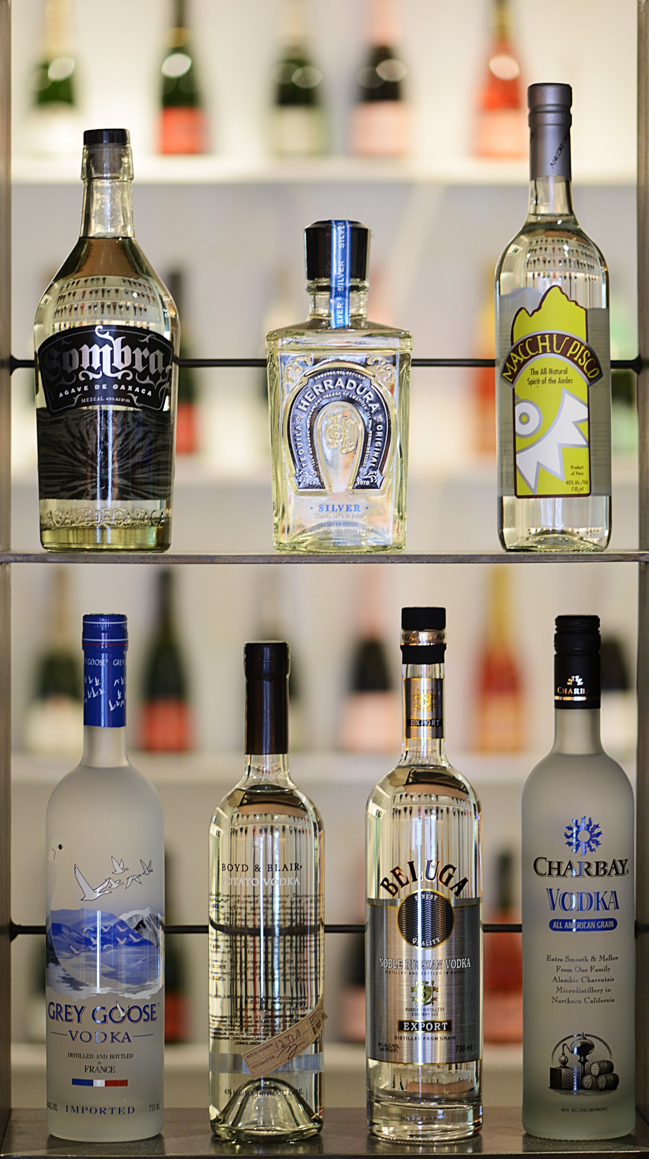 Selection of spirits bottles displayed on shelves at NoLita Wine Merchants in New York.