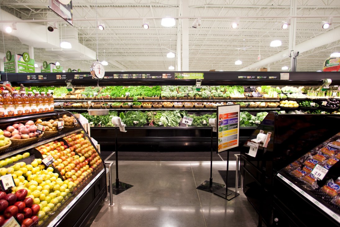 The Fresh Grocer produce section displaying colorful fresh fruits and vegetables under bright lighting.
