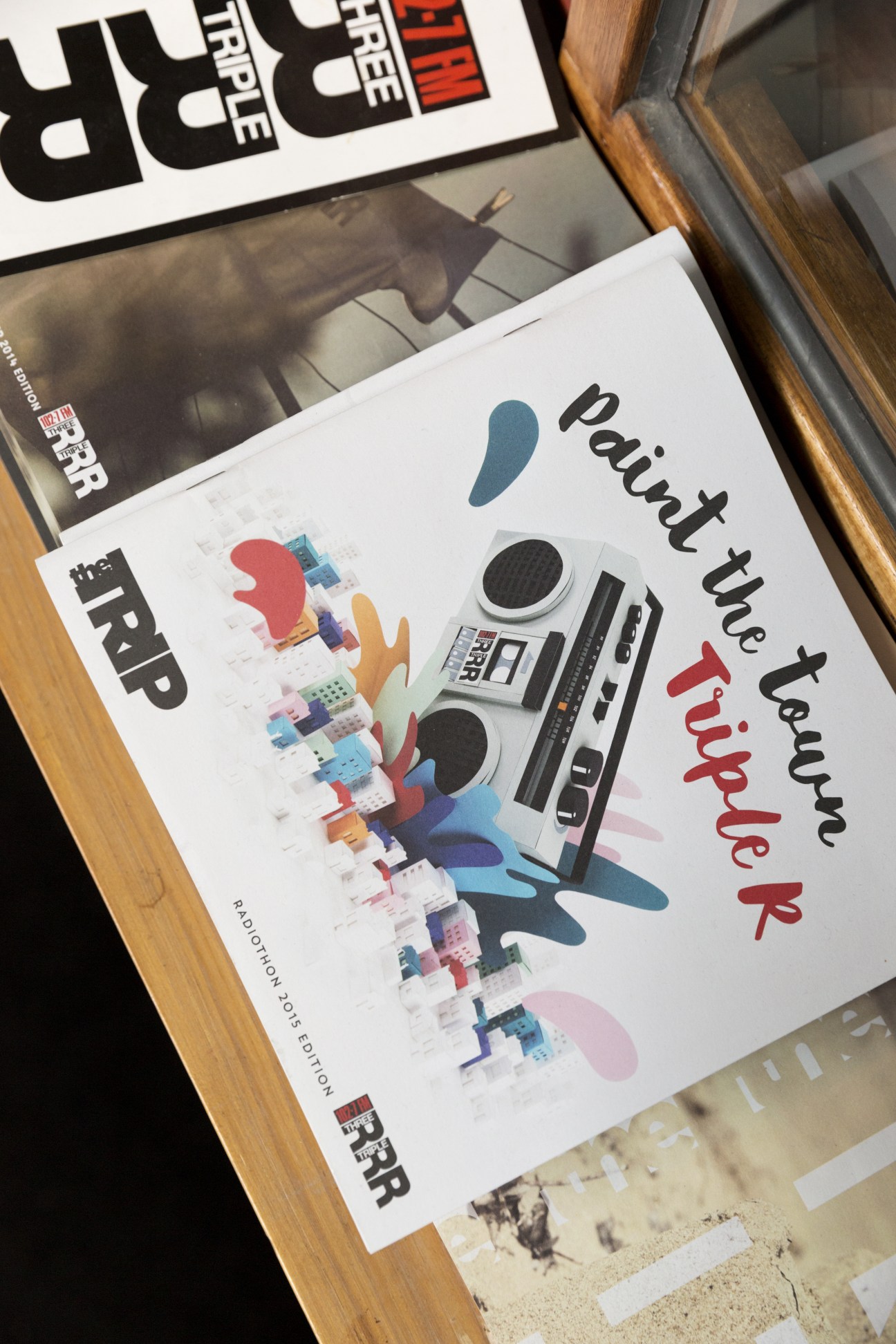 Triple R promotional materials and posters displayed on a wooden surface.