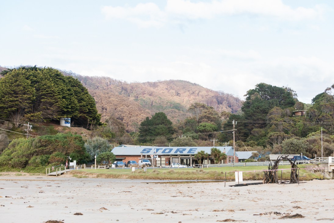 Wye River General Store viewed from the beach, with forested hills in the background.
