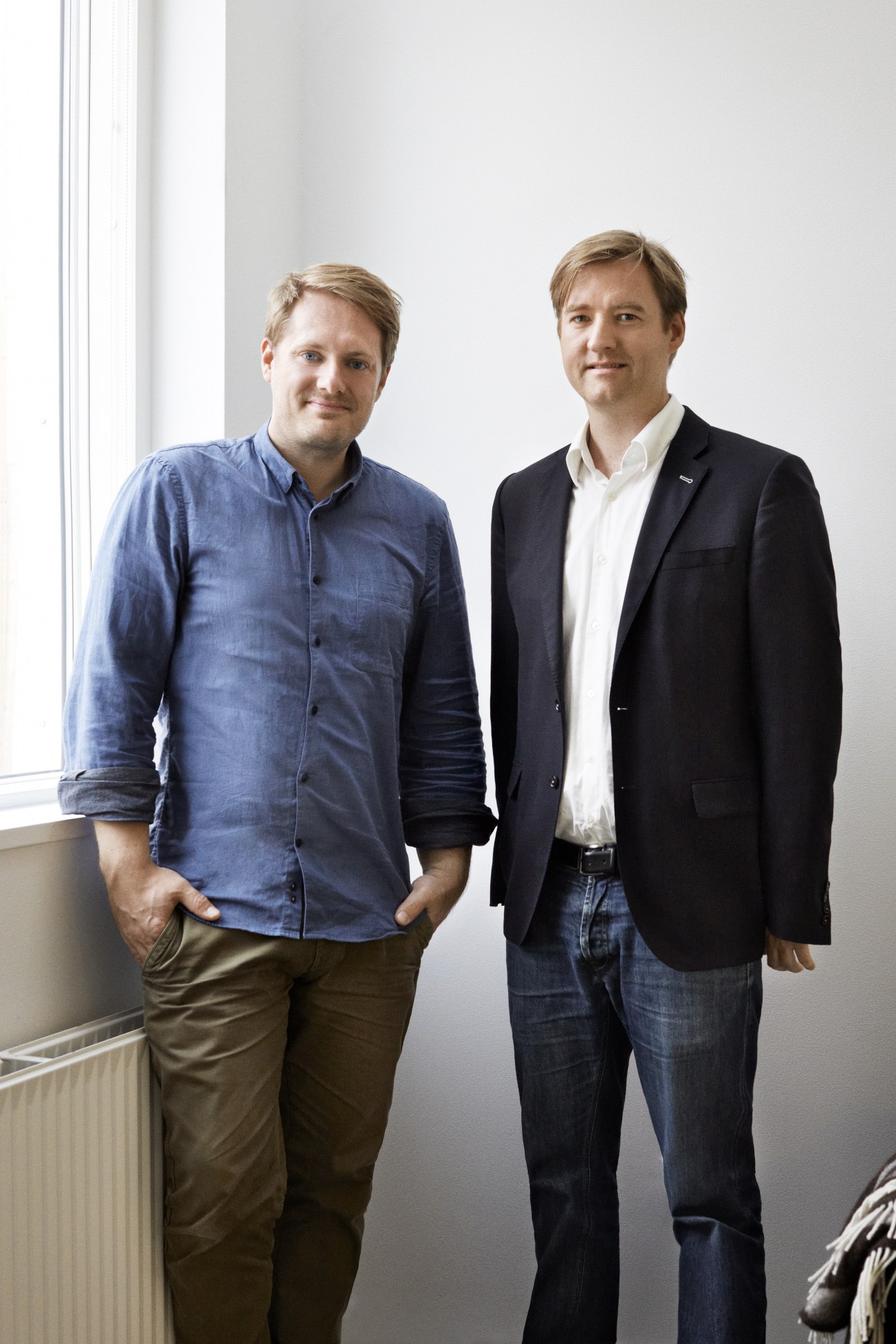 Two men standing by a window: Johannes Molander Pedersen in a blue shirt and Morten Rask Gregersen in a black blazer.