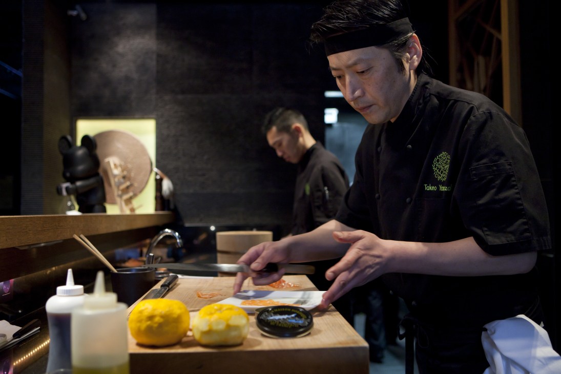 Head chef Takeo Yamazaki prepares salmon yuzu at Yoshi restaurant's sushi counter.
