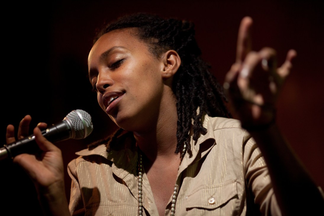 Munit Mesfin singing into a microphone at Club Alizé during rehearsal.