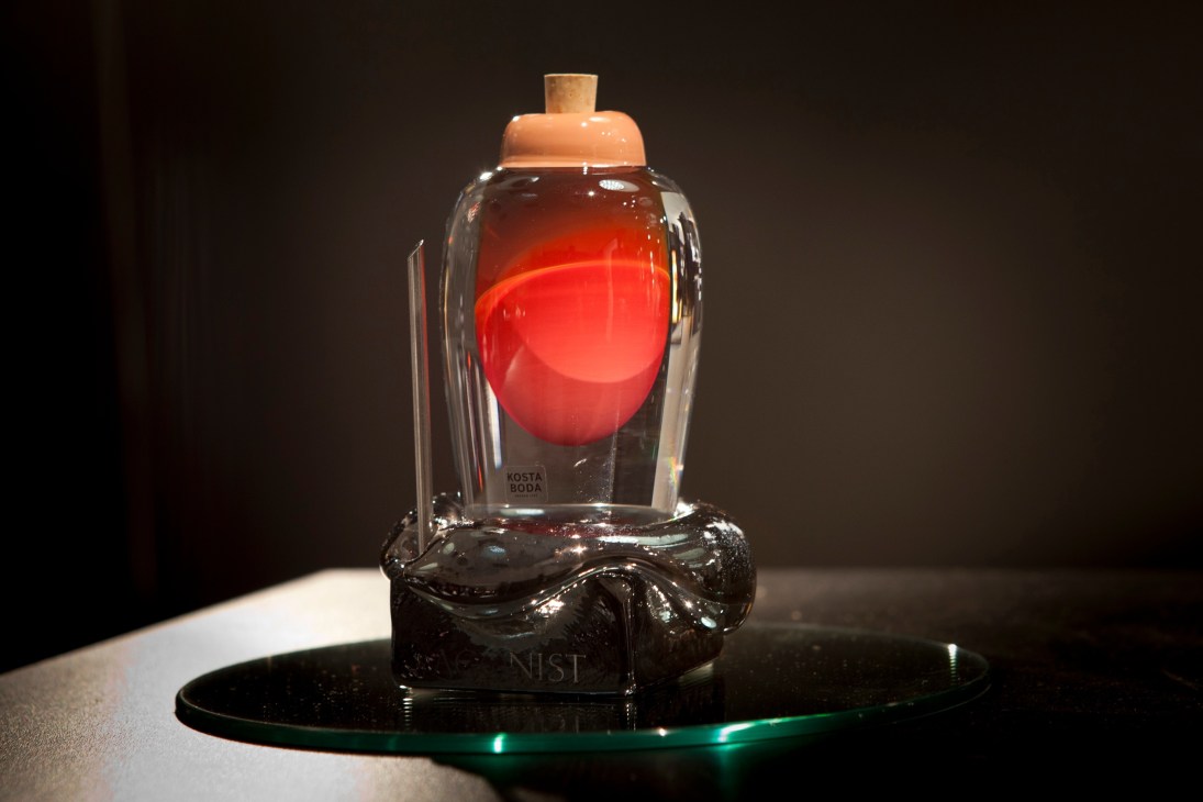 Agonist perfume bottle with hand-blown glass from Kosta Boda and sculptural black base on glass platform.