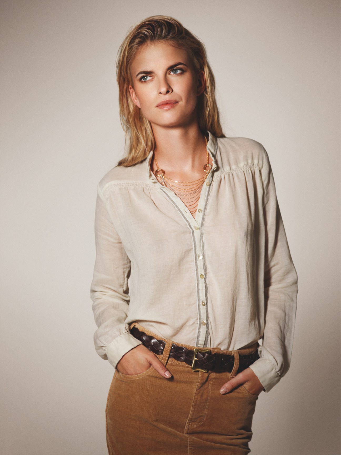Woman wearing a cream Bagutta shirt, Cartier necklace, J&M Davidson belt and Macphee skirt.