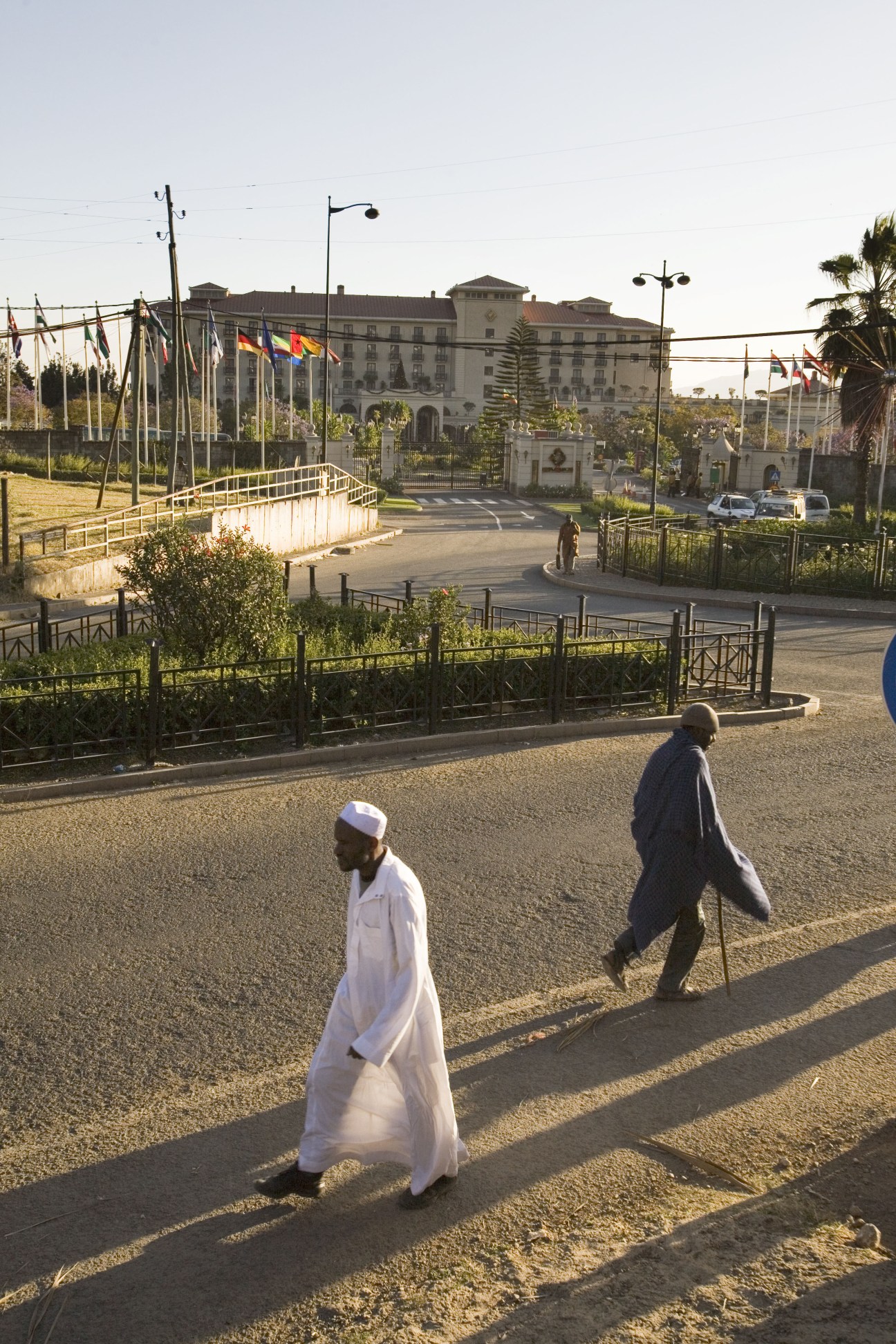 The Sheraton hotel in Addis Ababa with international flags and two pedestrians on street