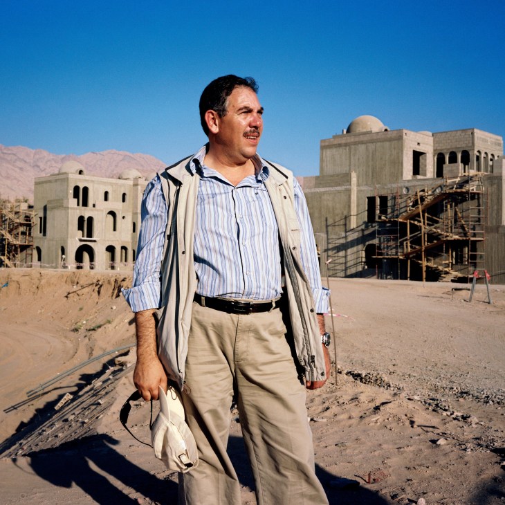 Shadi Majali, managing director of the Saraya Aqaba project, stands on a construction site with unfinished beige buildings behind him.