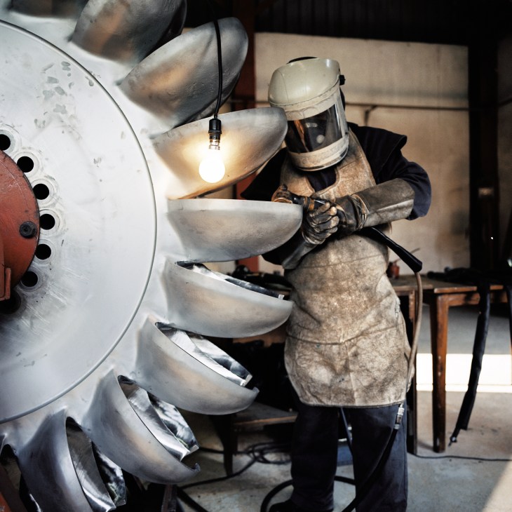 Engineer at the Khimti hydro plant works on one of its two-tonne steel turbines