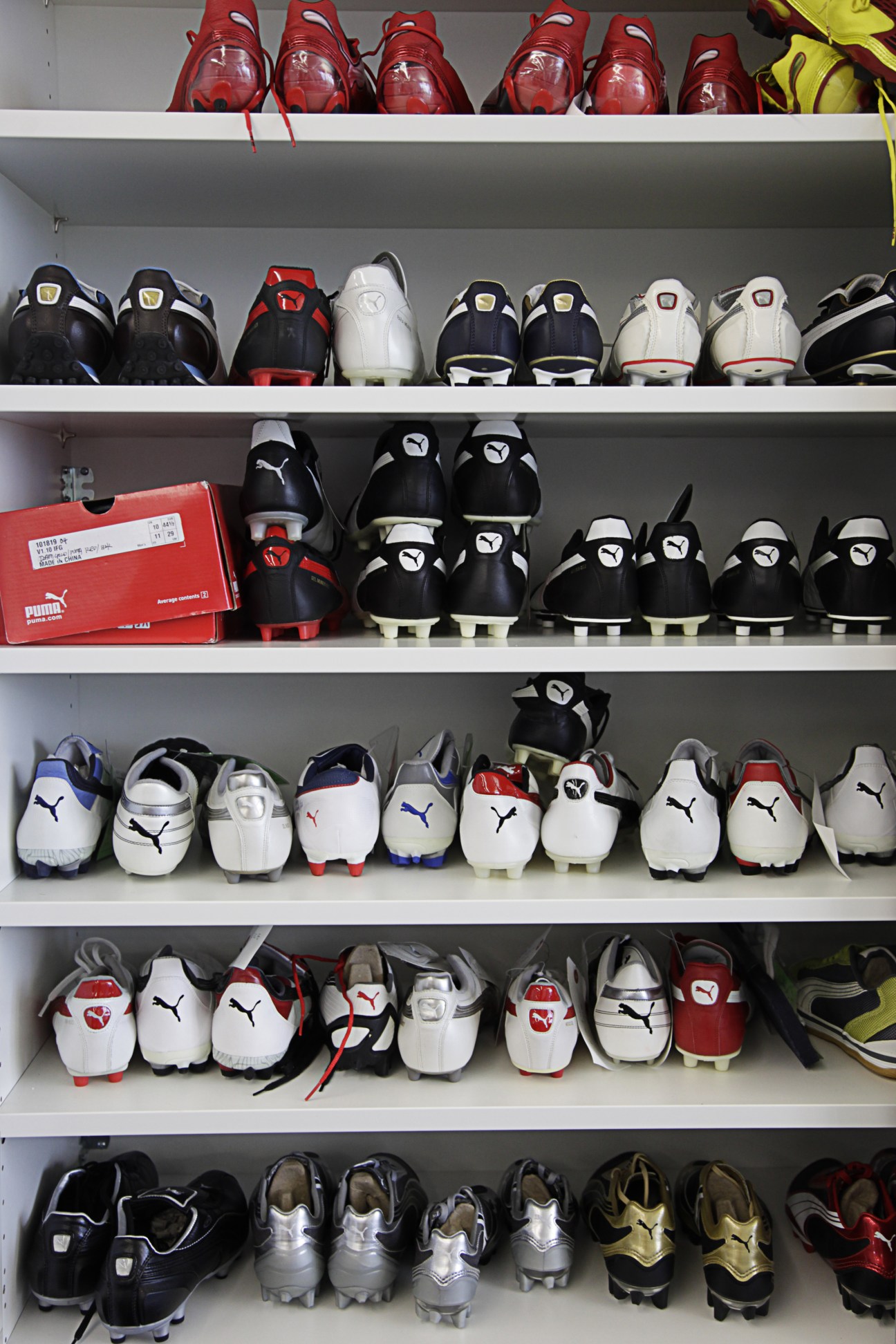 Shelves displaying a range of Puma football boots in various colors and styles.