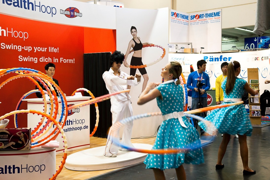 An Elvis impersonator in white jumpsuit demonstrates Health Hoop fitness equipment at the Fibo trade show.
