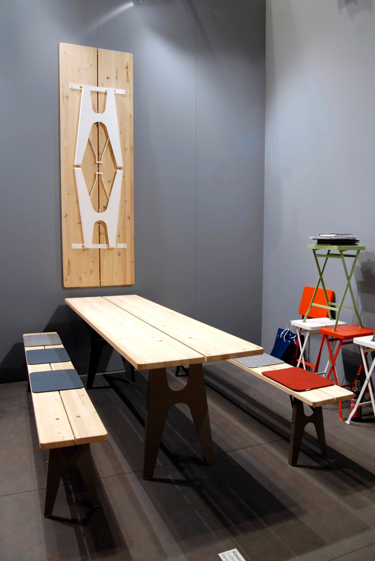 Ludwig collapsible picnic table by Richard Lampert with wooden benches and wall-mounted storage.