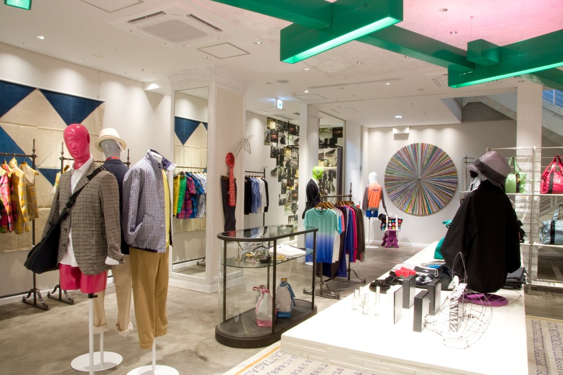 Interior of Tomorrowland's Tokyo store with colorful clothing displays, mannequins, and modern retail fixtures.