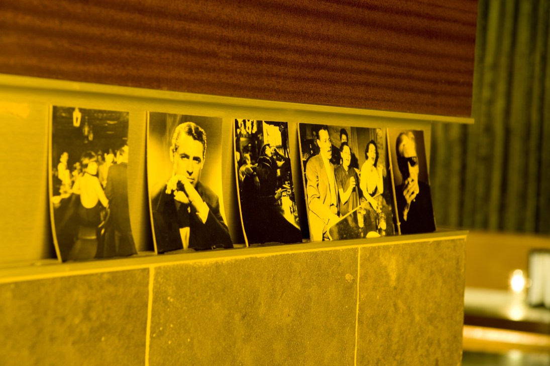 Old Hollywood postcards displayed on a yellow shelf in Bar Centro.