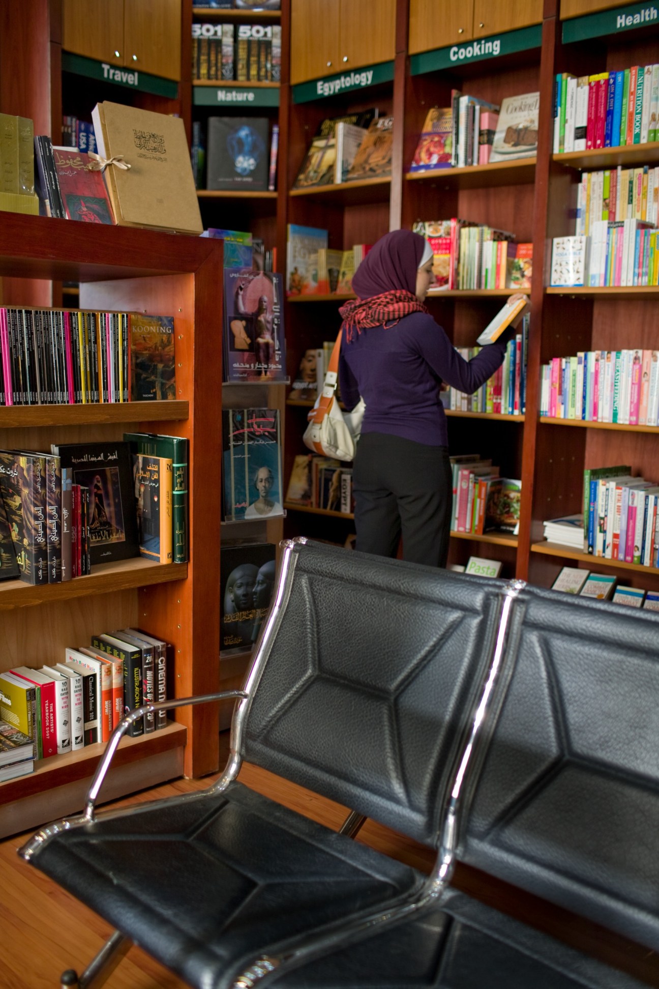 A woman browses books on wooden shelves inside Dar El Shorouk bookshop in Cairo.