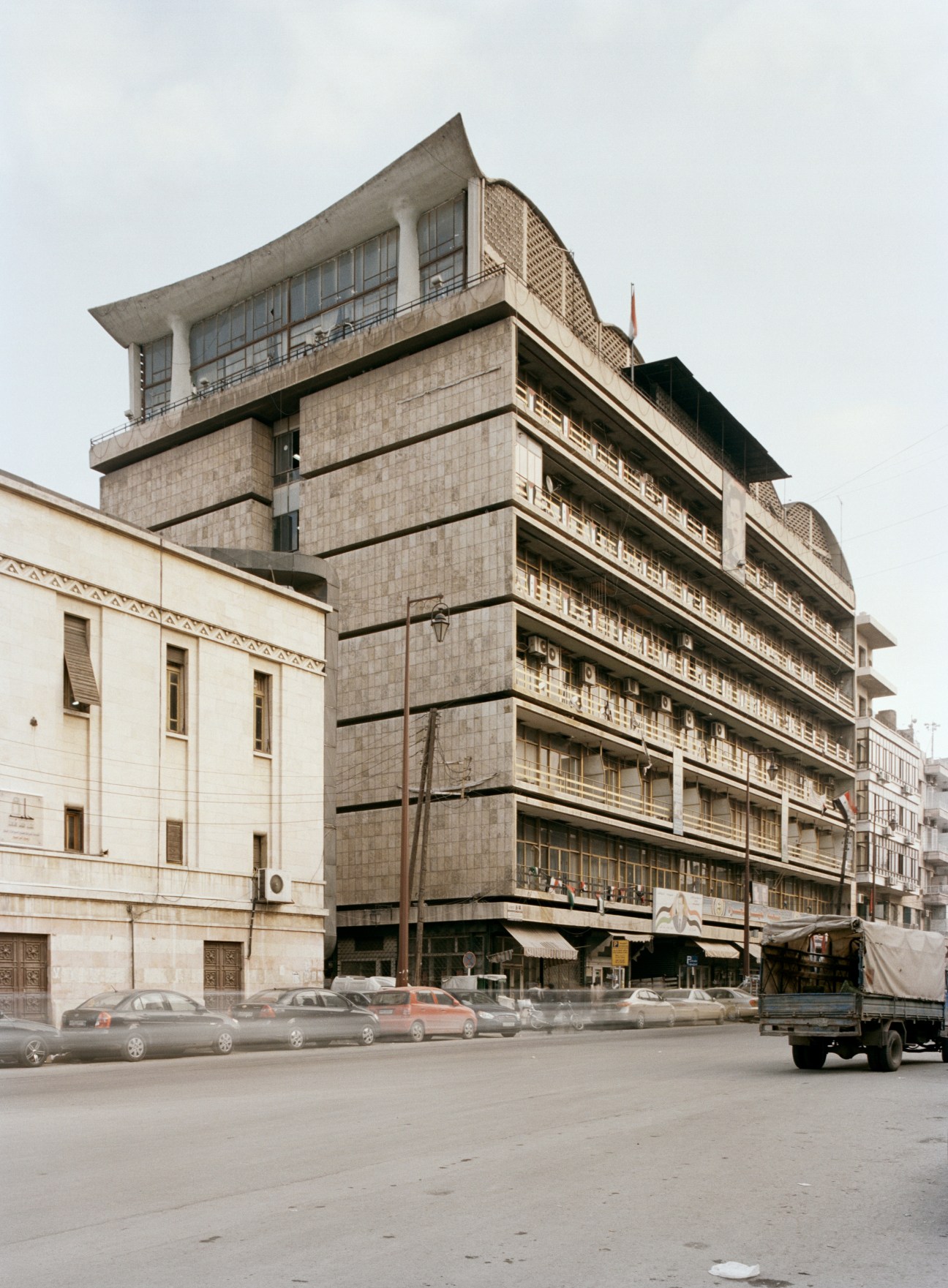 1960s municipal building in Bab al Faraj, a modernist concrete structure with stacked horizontal levels and geometric forms.