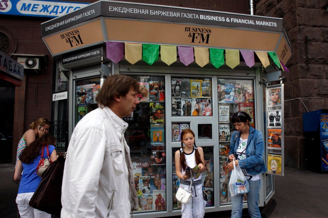 A newspaper and magazine kiosk on Pushkin Square in Moscow displaying colorful publications behind glass windows.