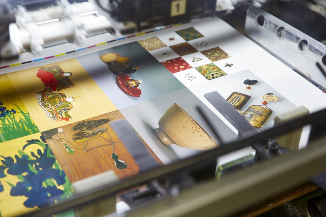 Colorful art postcards arranged on a printing press with color calibration guides and Japanese artwork designs.