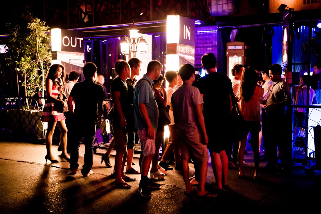 People queue outside an illuminated nightclub entrance on Royal City Avenue in Bangkok.