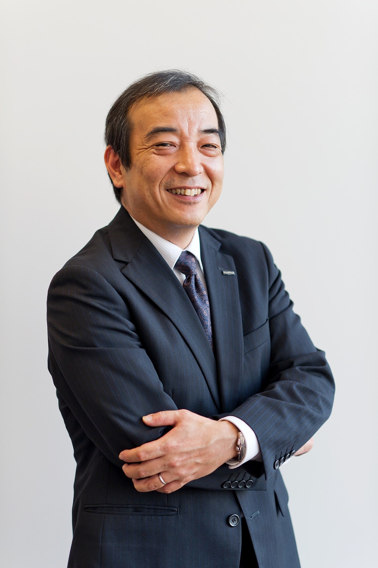 Portrait of Masaya Seki, senior operations manager at Fujifilm's life-science products division, smiling in business attire.