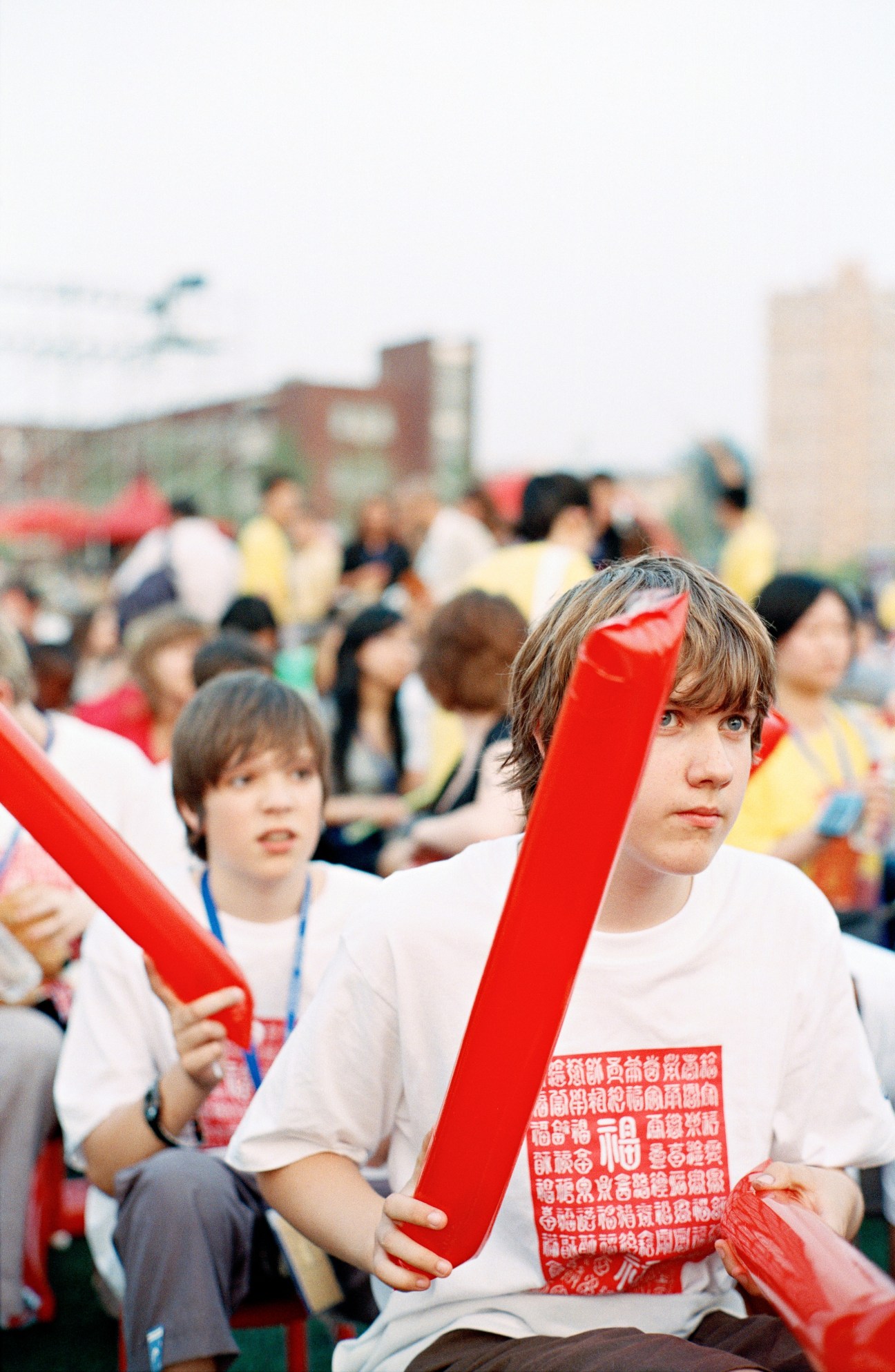 Young students holding red decorative objects at the Confucius Institute Chinese Bridge summer camp opening ceremony in Beijing.
