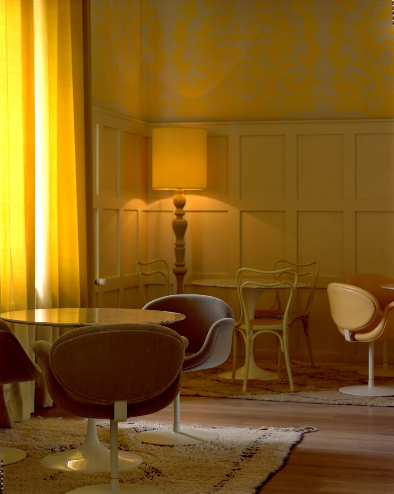 Interior of Das Kranzbach wellness retreat with modern chairs, warm lighting, and panelled walls.