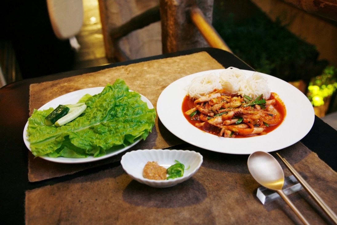 Korean dishes at Bissori restaurant in Tokyo including spicy squid with noodles and fresh lettuce wraps.