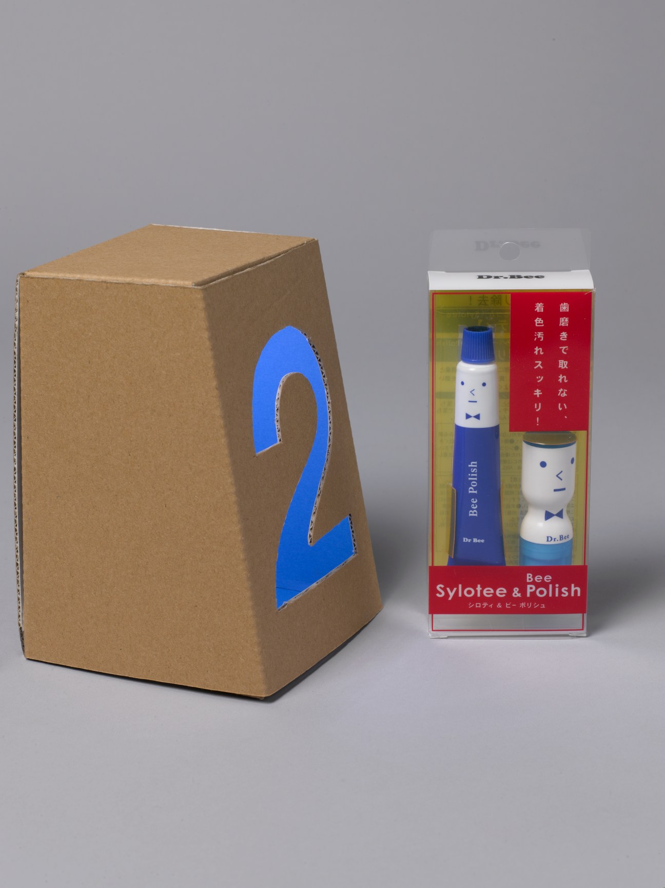 Sylotee & Polish tooth whitening kit with blue tube and white container with cartoon face design next to cardboard box with blue number 2