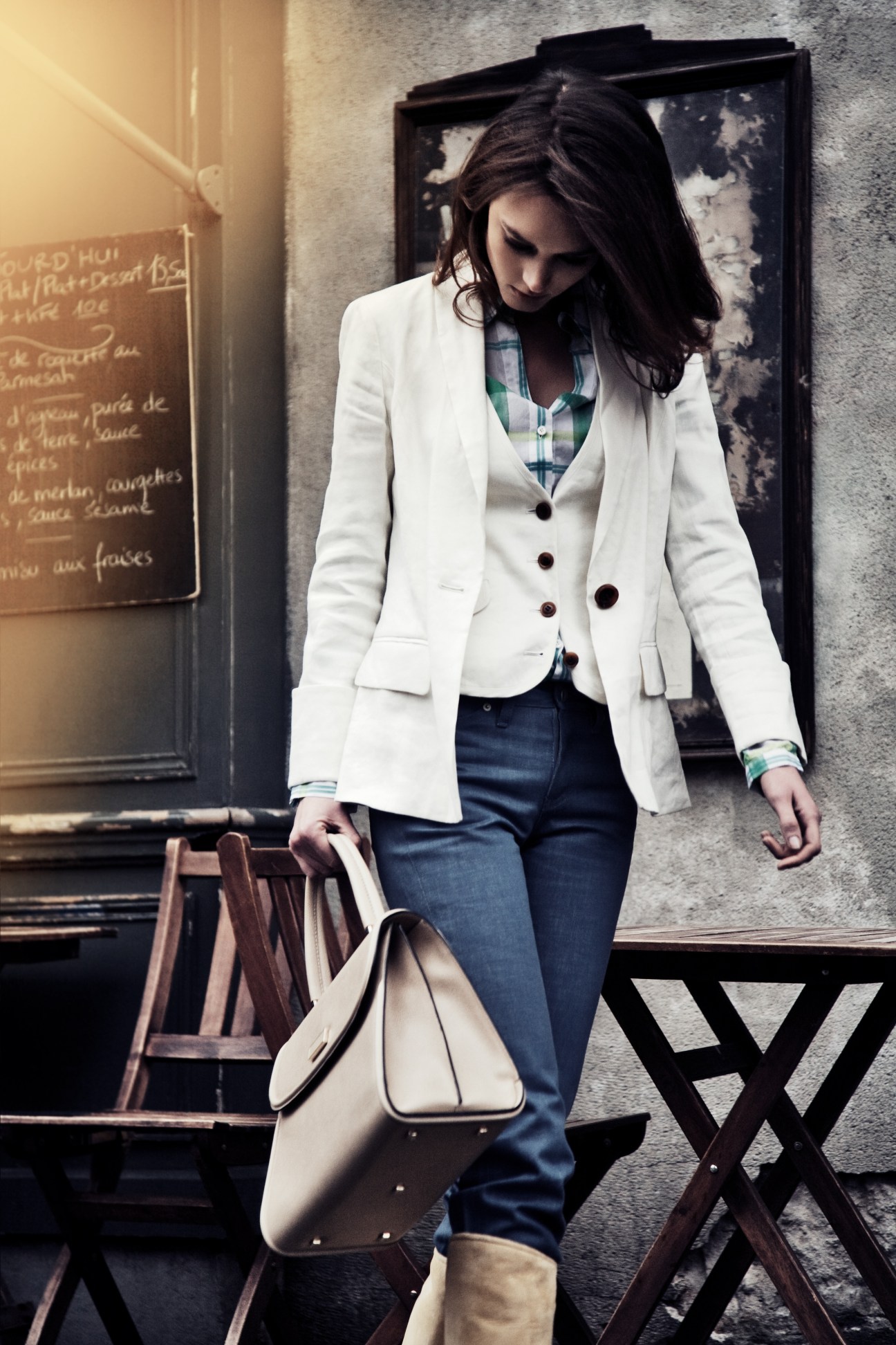 Woman wearing a white double-breasted Diane von Furstenberg jacket, checked shirt, and Kitsuné jeans on a Paris street.
