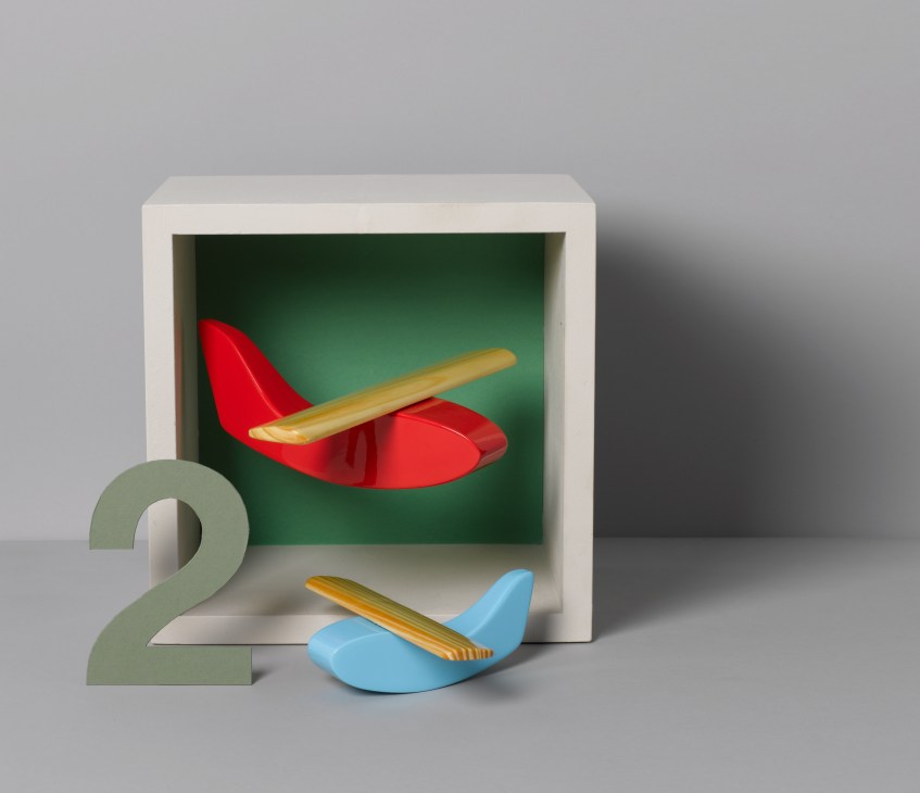 Normann Copenhagen wooden toy airplane with wooden stand and number two, displayed in white box with green interior.