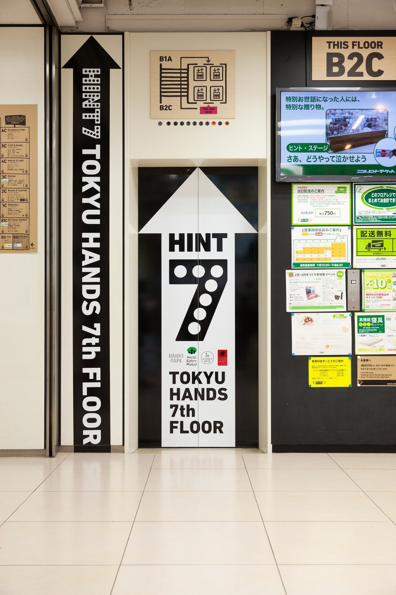 Elevator entrance at Tokyu Hands 7th floor with directional signage and store map on wall.