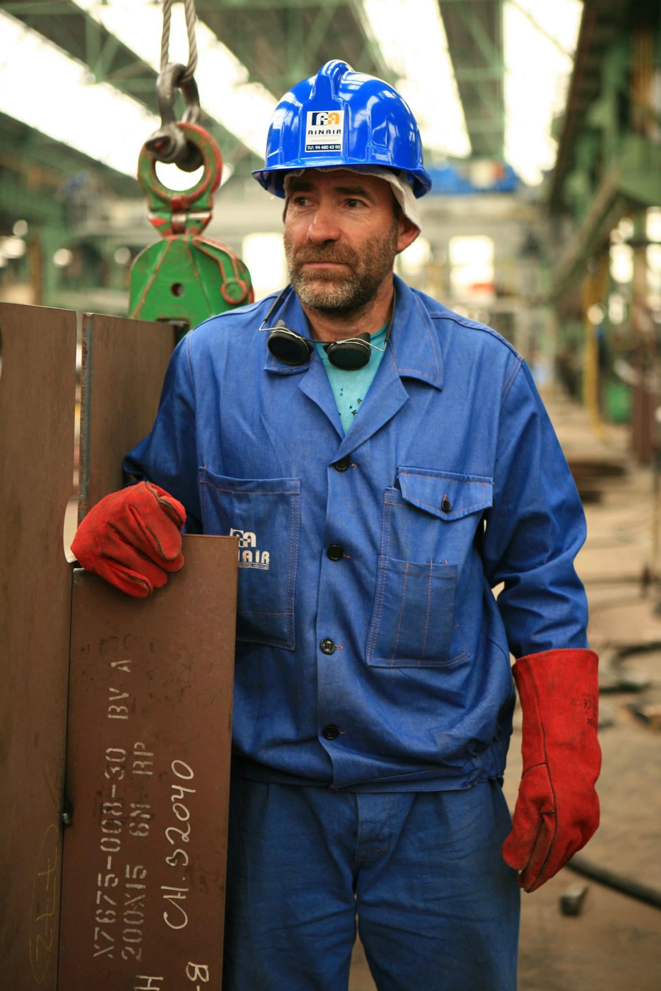Spanish shipyard worker Rafa Vilchez wearing blue coveralls and hard hat at La Naval shipyard.