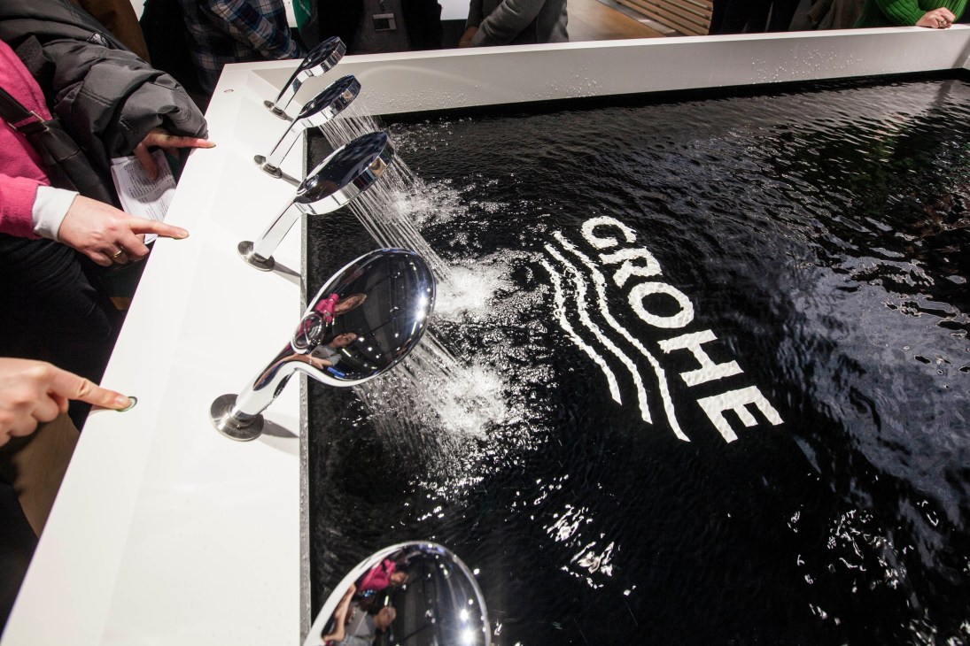 GROHE shower heads displaying multiple spray patterns over water on dark surface with GROHE branding.
