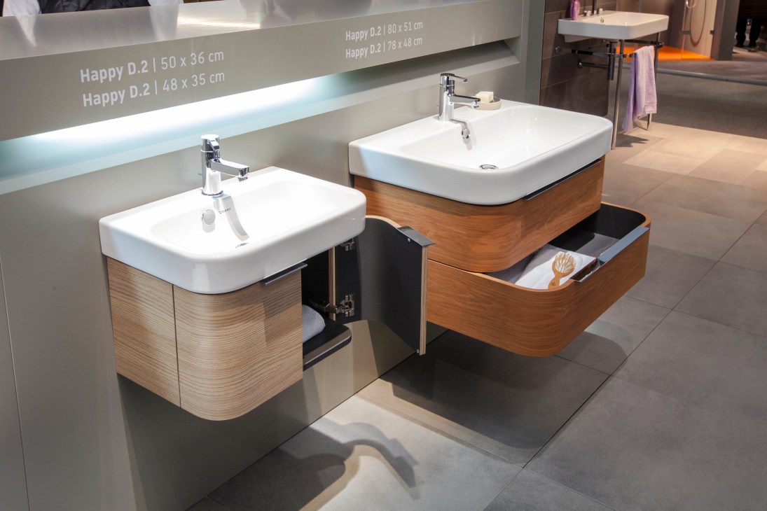 Duravit's Happy D.2 bathroom fixtures with white ceramic basins and wood-grain vanity units on display.