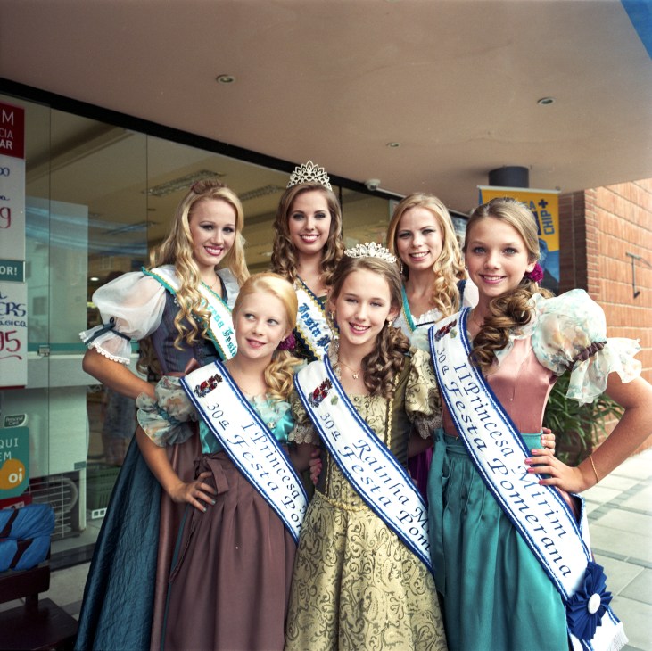 Young women in traditional German dirndl dresses and tiaras pose together at the Festa Pomerana festival in Pomerode, Brazil.