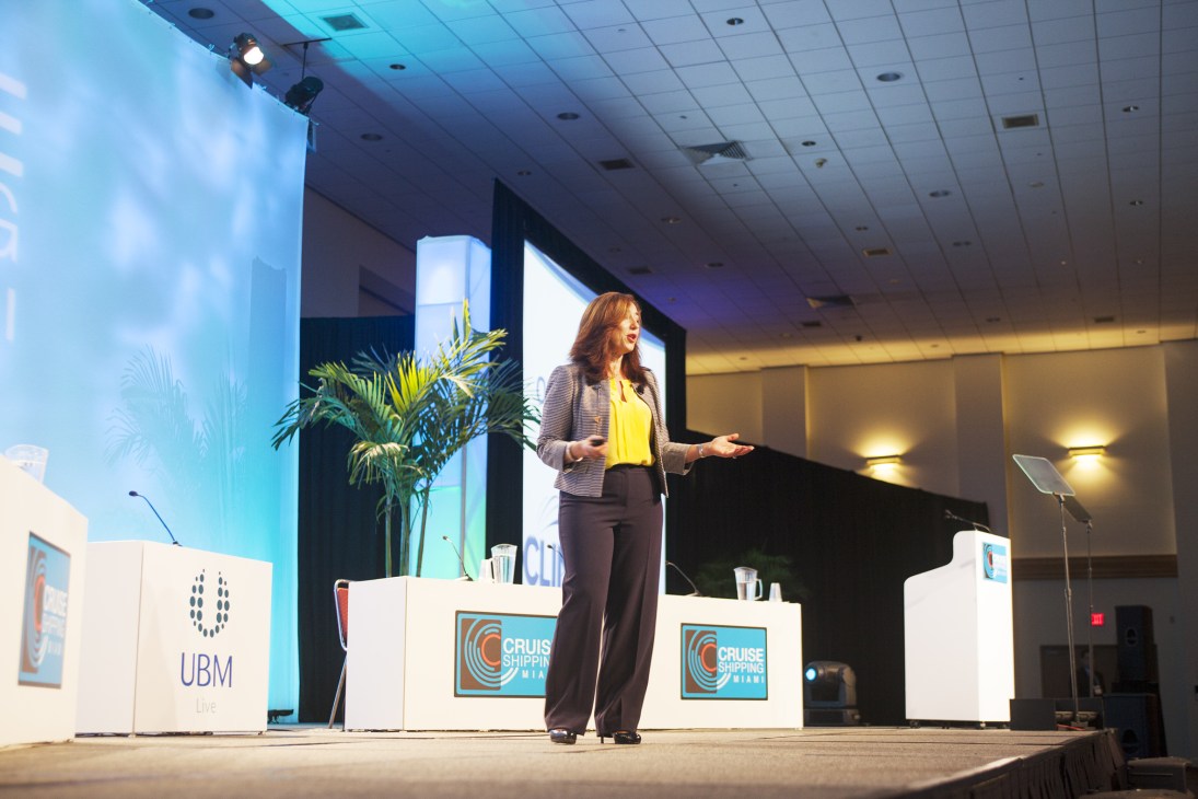 Christine Duffy, president and CEO of Cruise Lines International Association, speaking at a podium during the Cruise Shipping Miami conference.