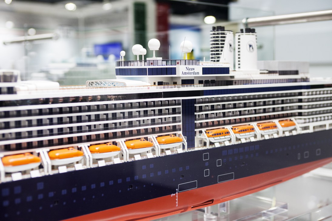 Detailed scale model of the Fincantieri cruise ship Nieuw Amsterdam with orange lifeboats and multiple deck levels.