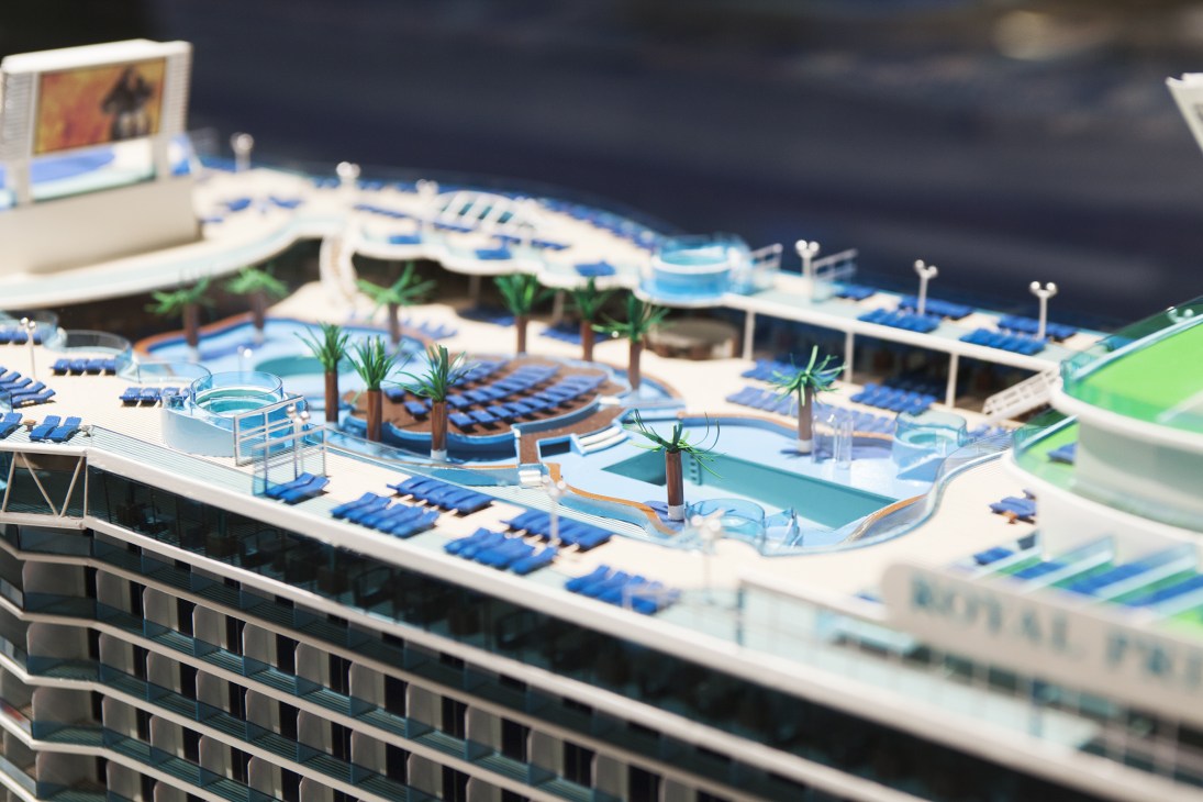 Scale model of the Royal Princess cruise ship showing deck layout with pools, loungers, and palm trees.