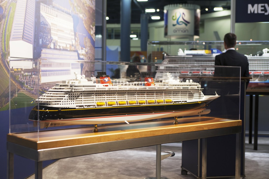 Scale model of the Disney Dream cruise ship displayed in a glass case at a convention.