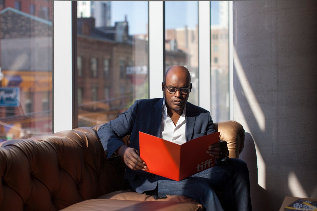 Cameron Bailey reviews his schedule in an office with floor-to-ceiling windows overlooking Toronto's skyline.